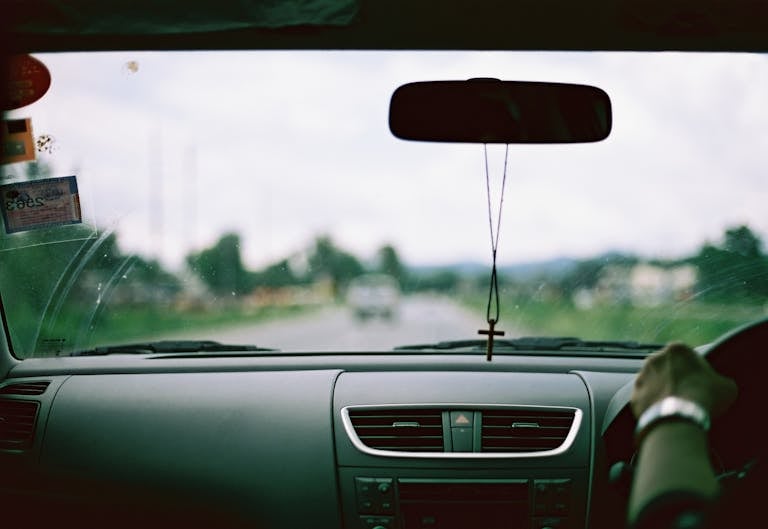 A Pendant with a Cross Handing on a Rear-view Mirror in the Car