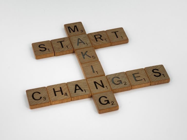 Close-Up Shot of Scrabble Tiles on a White Surface