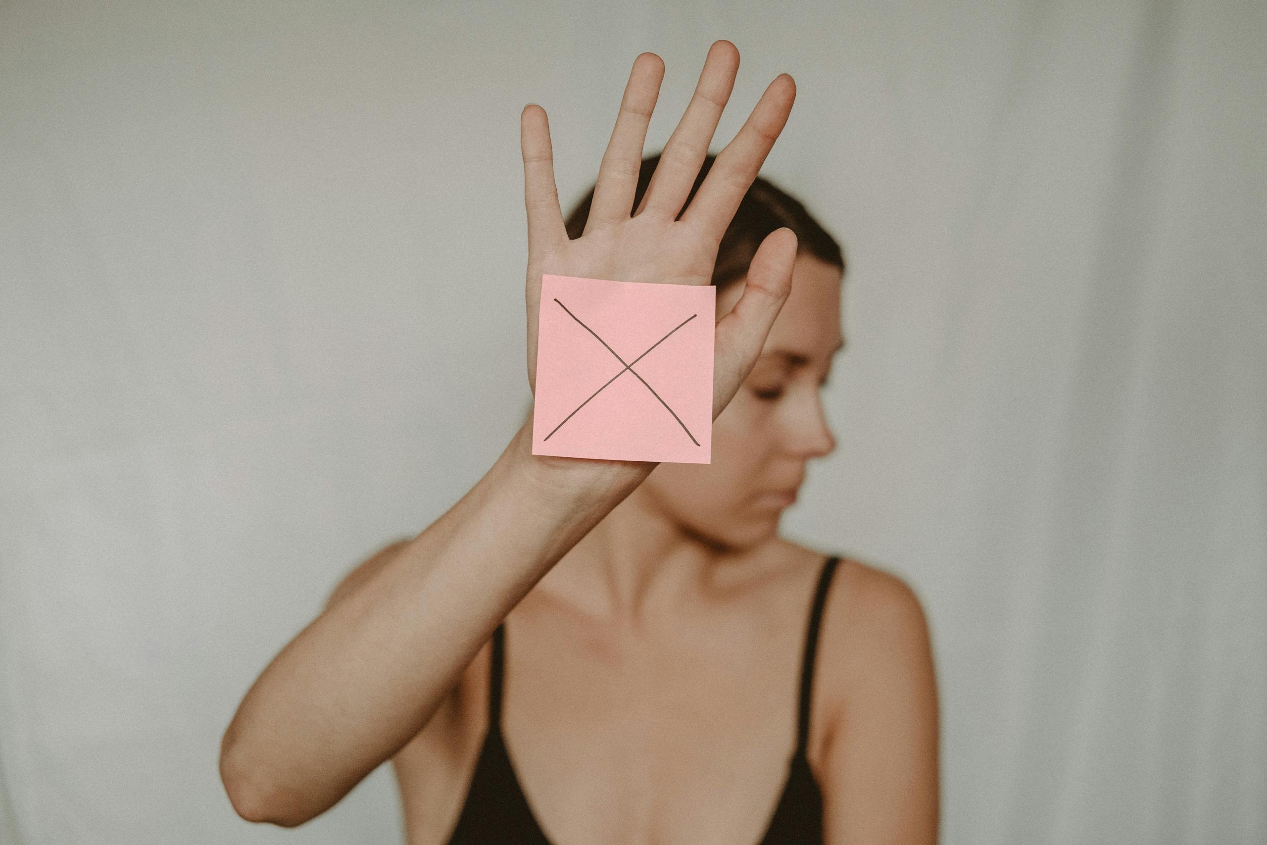 Woman with paper with cross sign